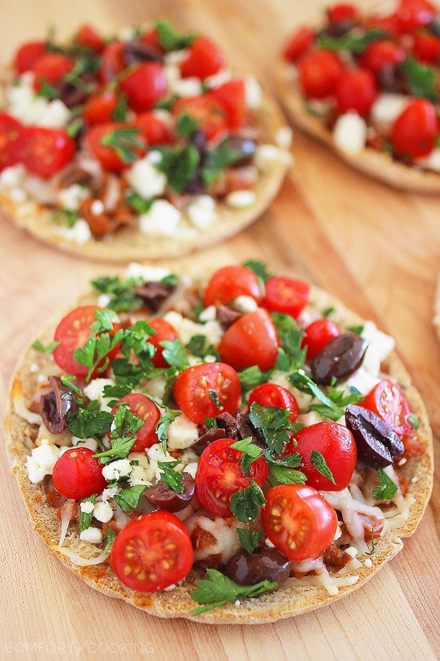 Greek Pita Pizzas – Super easy & full of Mediterranean flavor. Creamy feta, fresh tomatoes and a quick homemade tomato sauce make them mouthwatering!| thecomfortofcooking.com