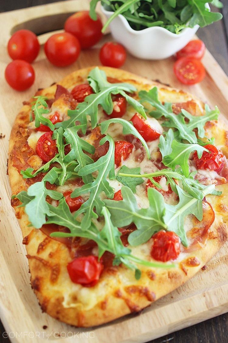 Proscuitto, Arugula and Tomato Naan Pizza – These crisp, colorful pizzas with tomatoes, prosciutto and fresh arugula take only 10 minutes for a healthy lunch or dinner! | thecomfortofcooking.com