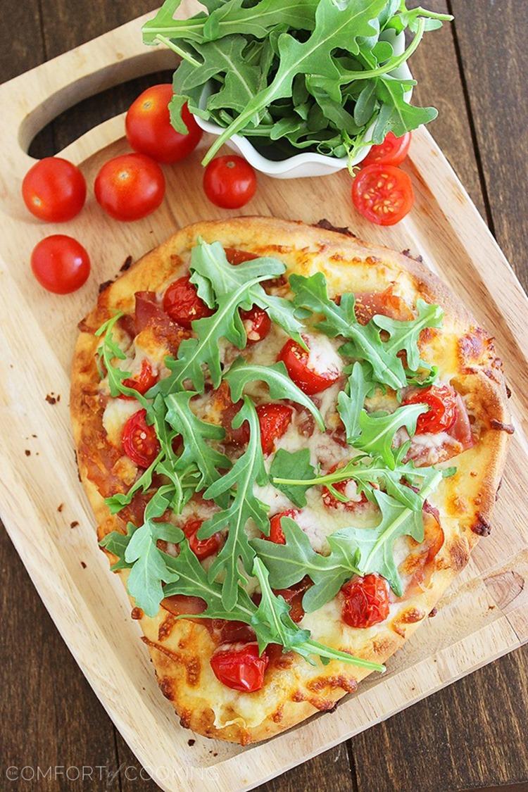 Proscuitto, Arugula and Tomato Naan Pizza – These crisp, colorful pizzas with tomatoes, prosciutto and fresh arugula take only 10 minutes for a healthy lunch or dinner! | thecomfortofcooking.com