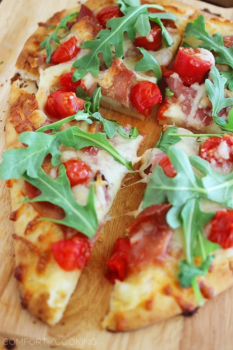 Proscuitto, Arugula and Tomato Naan Pizza – These crisp, colorful pizzas with tomatoes, prosciutto and fresh arugula take only 10 minutes for a healthy lunch or dinner! | thecomfortofcooking.com