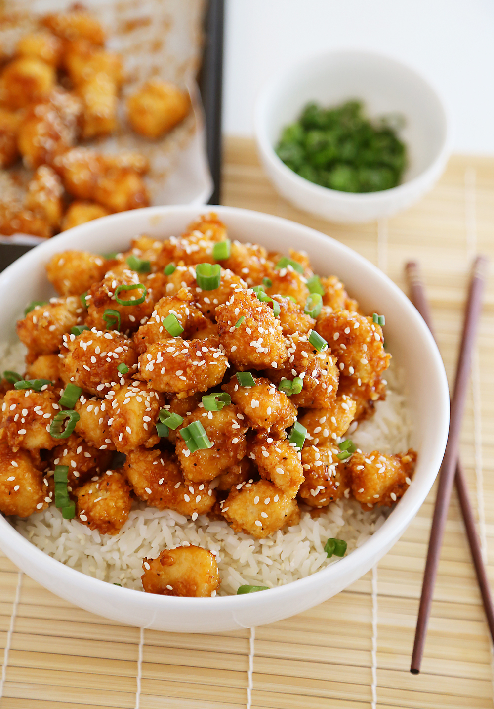 Crispy Baked Honey Garlic Chicken – Chicken bites in a sticky honey-Sriracha sauce are a weeknight meal or party appetizer! Thecomfortofcooking.com