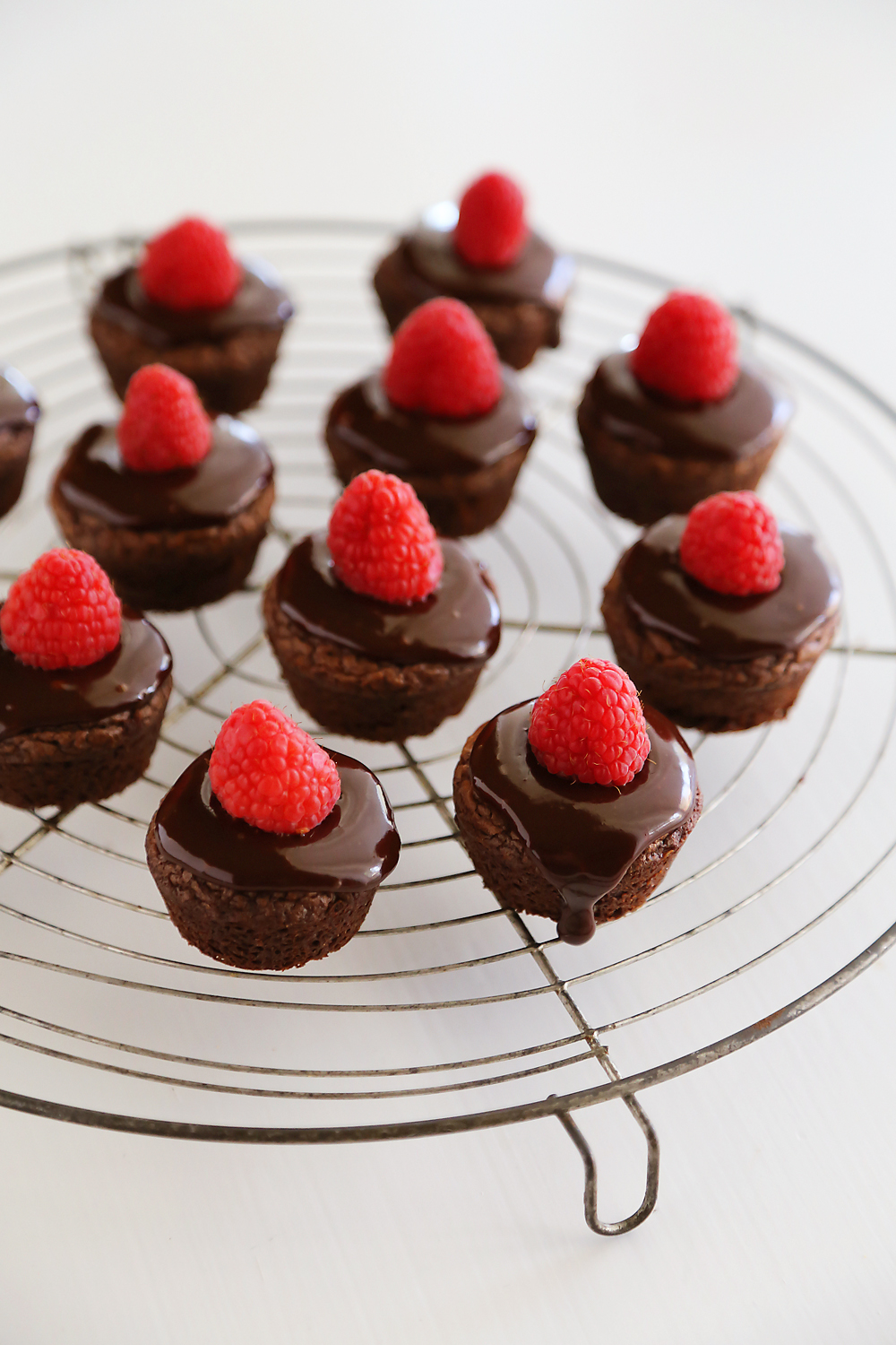 Easy Raspberry Ganache Brownie Bites - Fudgy brownie bites (baked in mini muffin tins) with chocolate ganache and raspberries are so easy and elegant! Thecomfortofcooking.com