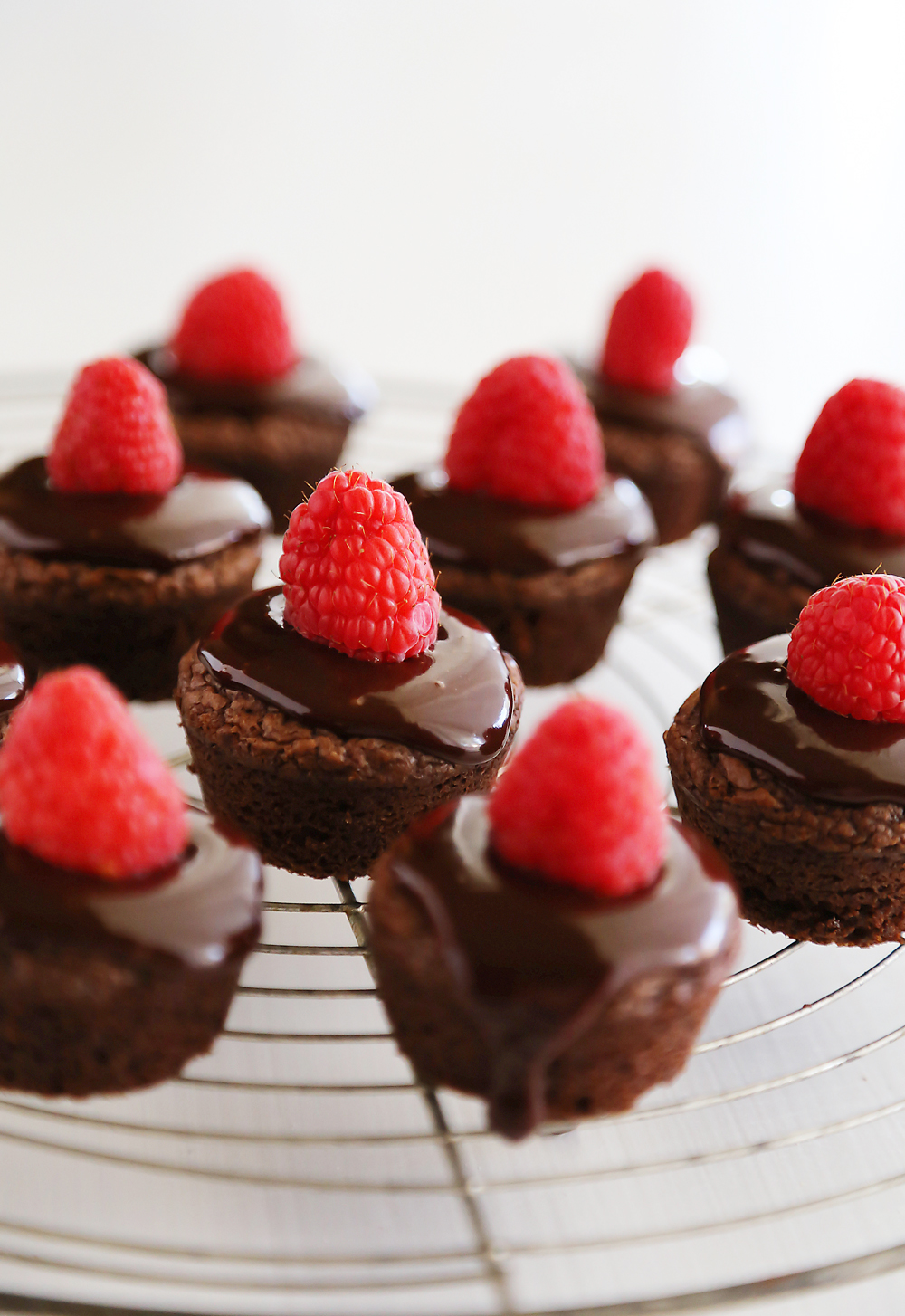 Easy Raspberry Ganache Brownie Bites - Fudgy brownie bites (baked in mini muffin tins) with chocolate ganache and raspberries are so easy and elegant! Thecomfortofcooking.com