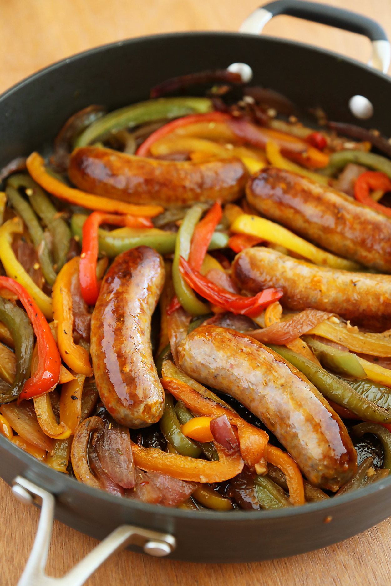 Skillet Italian Sausage, Peppers and Onions - Easy comfort food for weeknights & game days! Serve over pasta, polenta, potatoes or on warm crusty rolls. Thecomfortofcooking.com