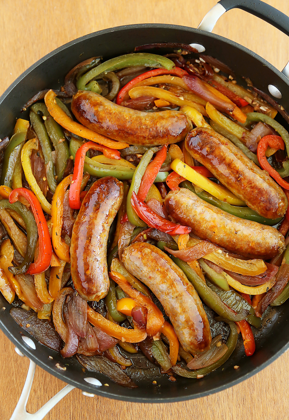 Skillet Italian Sausage, Peppers and Onions - Easy comfort food for weeknights & game days! Serve over pasta, polenta, potatoes or on warm crusty rolls. Thecomfortofcooking.com