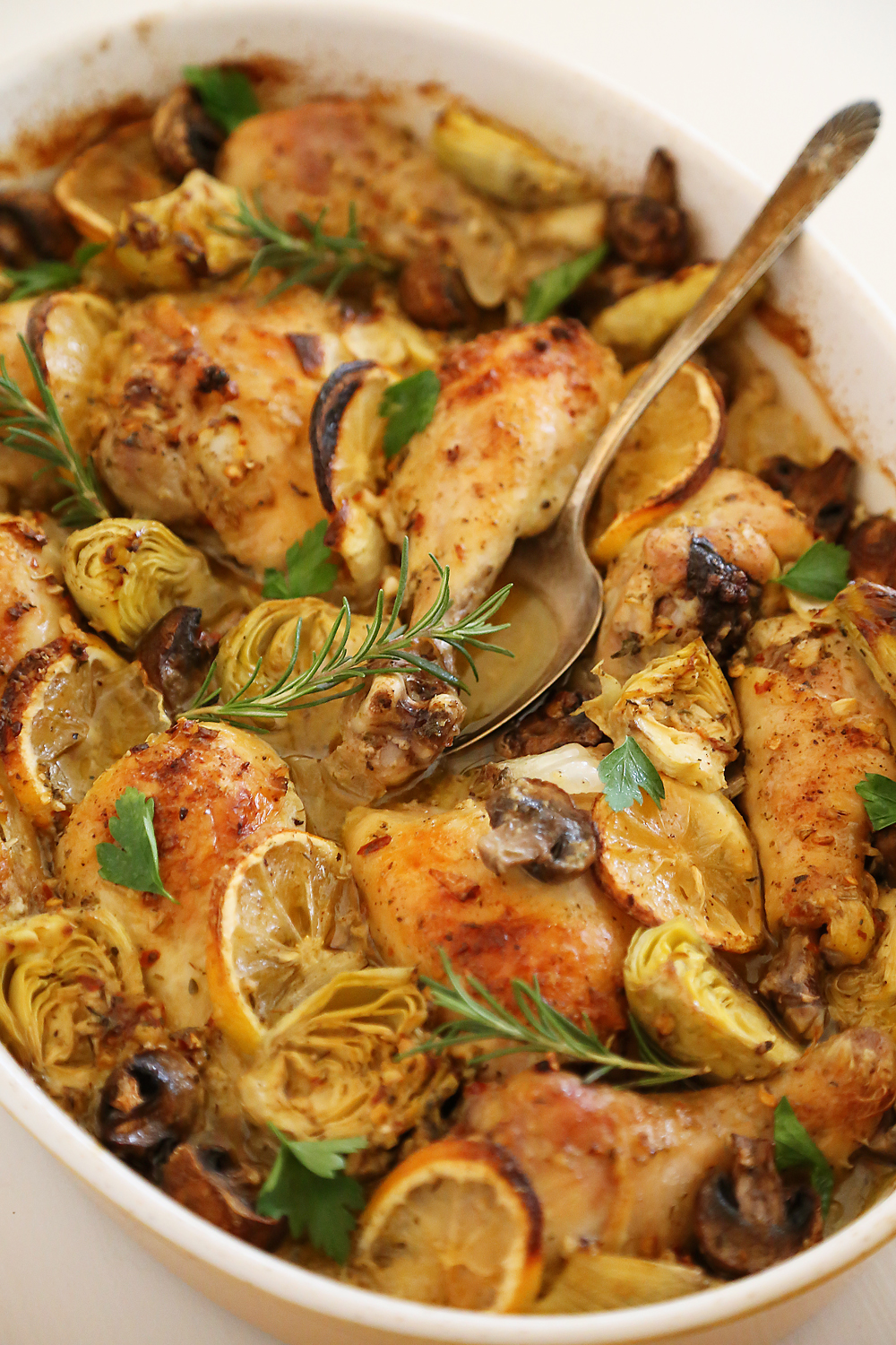 Lemon and Artichoke Oven Roasted Chicken - Crispy, tender lemon-roasted chicken with artichokes and mushrooms makes an easy, elegant dinner! Thecomfortofcooking.com