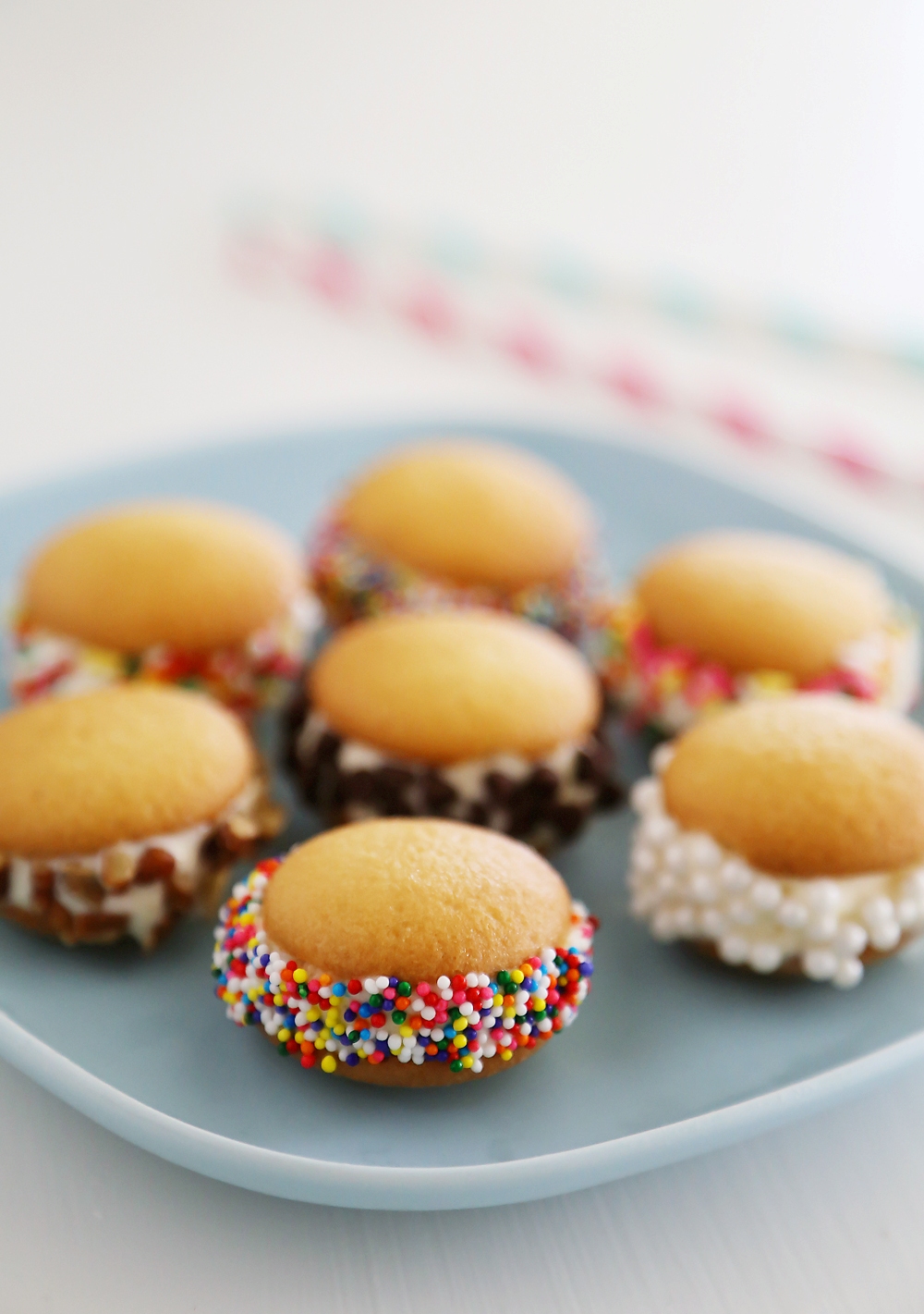 Mini Vanilla Wafer Ice Cream Sandwiches – The perfect quick + easy frozen treat! Roll in your favorite toppings and enjoy. thecomfortofcooking.com