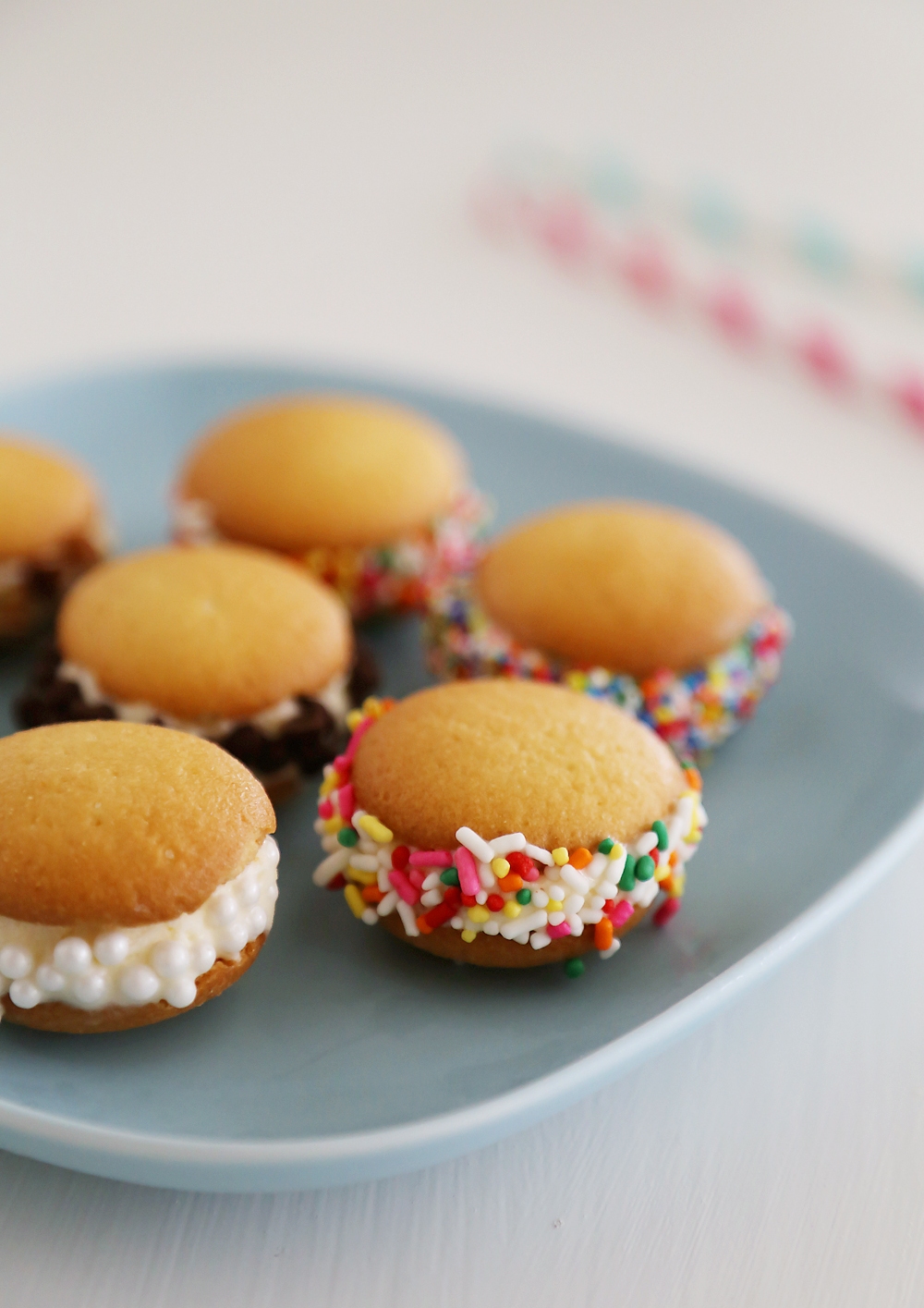 Mini Vanilla Wafer Ice Cream Sandwiches – The perfect quick + easy frozen treat! Roll in your favorite toppings and enjoy. thecomfortofcooking.com