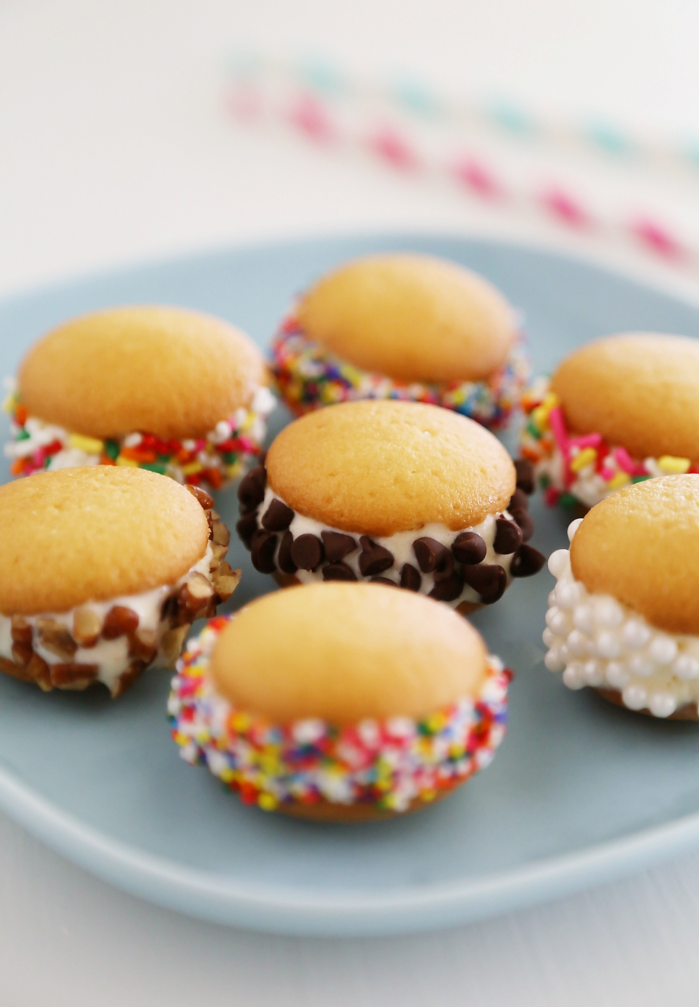 Mini Vanilla Wafer Ice Cream Sandwiches – The perfect quick + easy frozen treat! Roll in your favorite toppings and enjoy. thecomfortofcooking.com