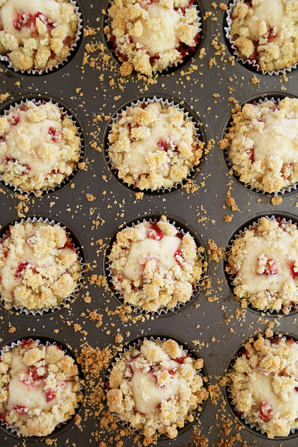 Strawberry Coffee Cake Muffins - Bursting with fresh berries and topped with a buttery coffee cake crumble. Thecomfortofcooking.com