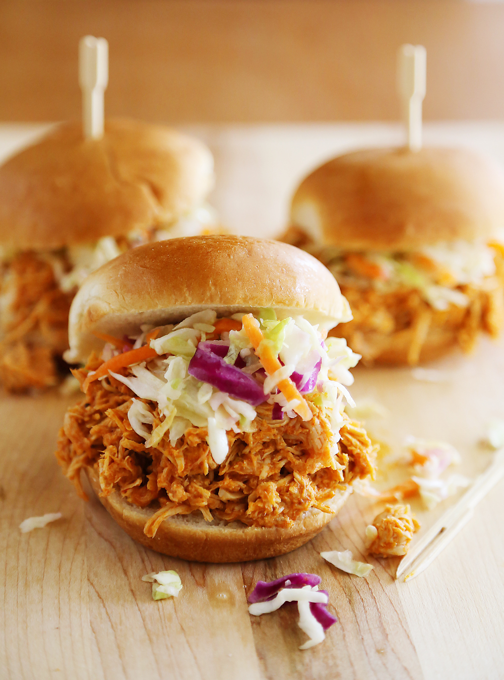 Slow Cooker Buffalo Chicken Sliders - Serve this tangy, tender slow cooked buffalo chicken on buttery toasted buns, or as lettuce wraps! Thecomfortofcooking.com