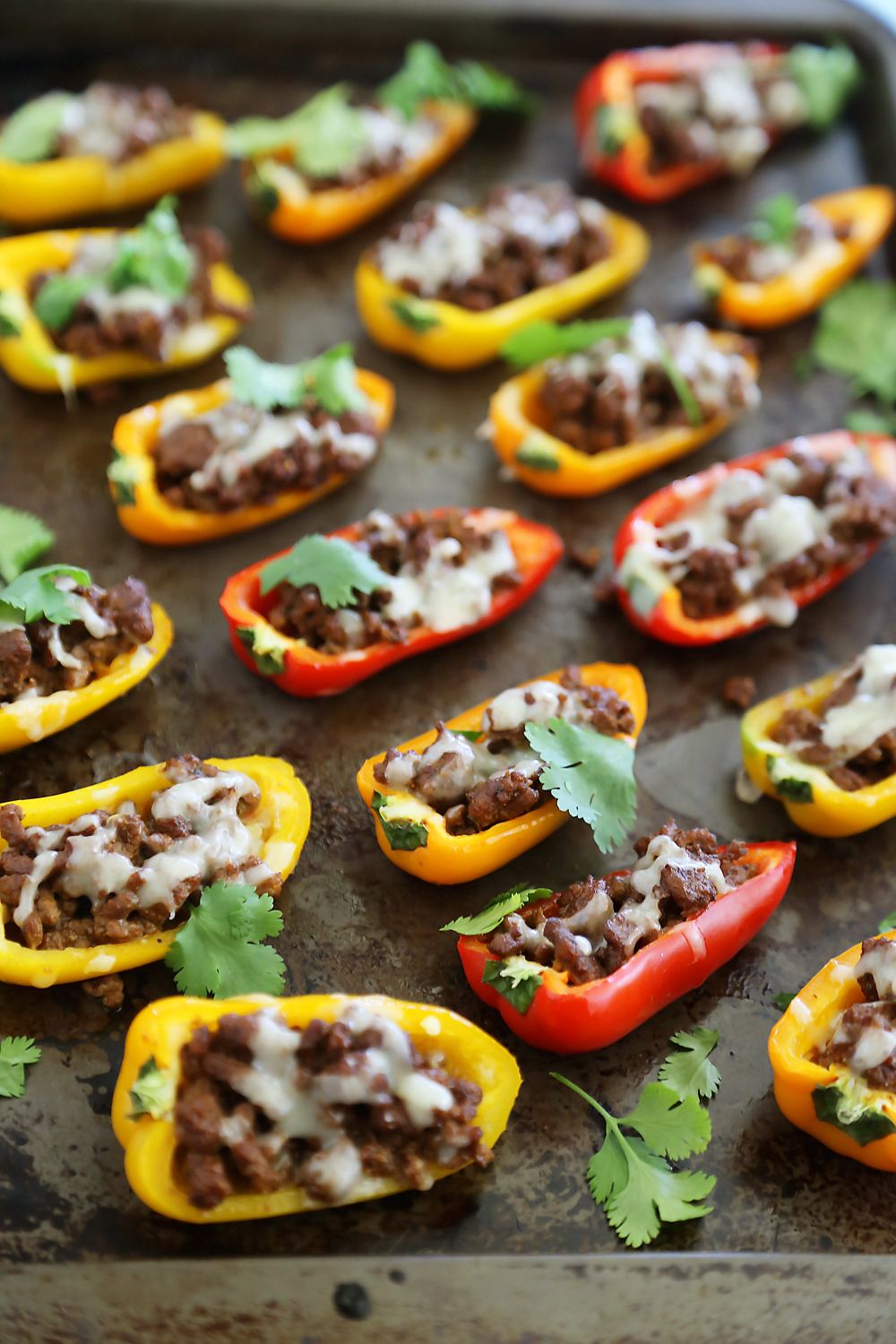 Mini Taco Stuffed Peppers with Cilantro Cream Sauce - Easy 5-ingredient spicy taco stuffed peppers with a creamy cool sauce. Thecomfortofcooking.com