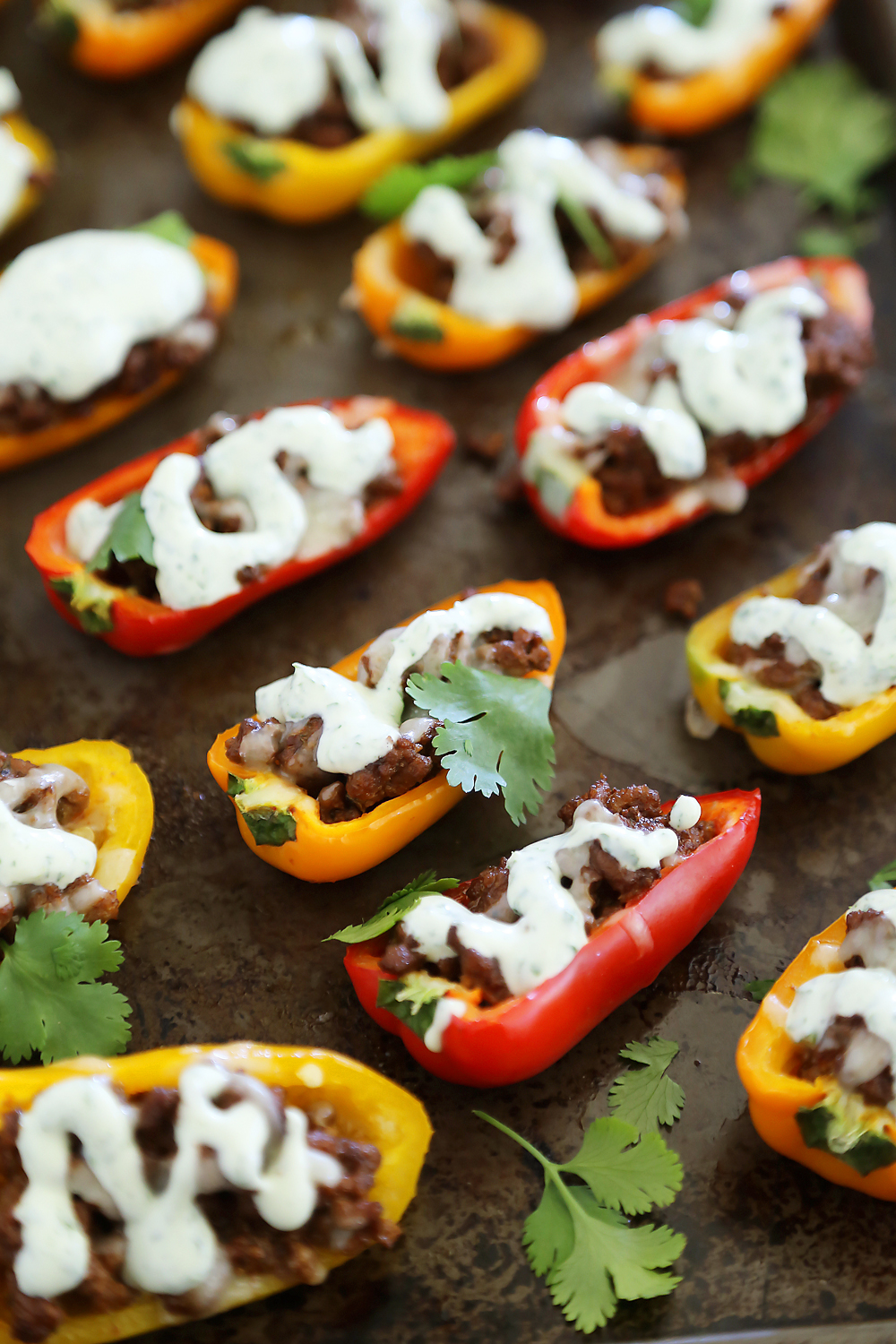 Mini Taco Stuffed Peppers with Cilantro Cream Sauce - Easy 5-ingredient spicy taco stuffed peppers with a creamy cool sauce. Thecomfortofcooking.com