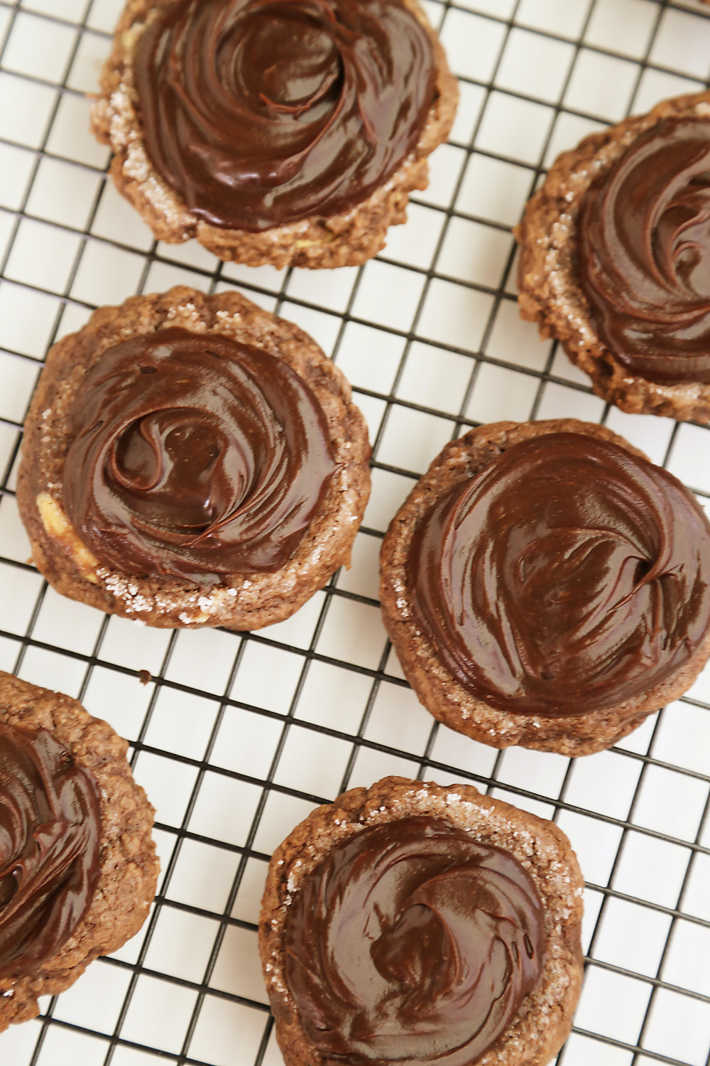 Frosted Peanut Butter Brownie Cookies - Gooey, fudgy chocolate brownie cookies with a surprise peanut butter center! Thecomfortofcooking.com