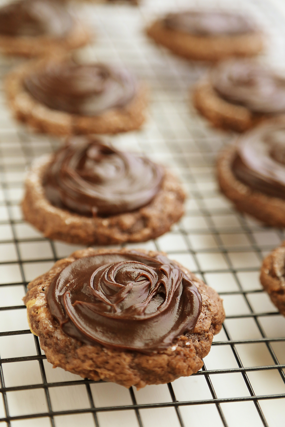 Frosted Peanut Butter Brownie Cookies - Gooey, fudgy chocolate brownie cookies with a surprise peanut butter center! Thecomfortofcooking.com