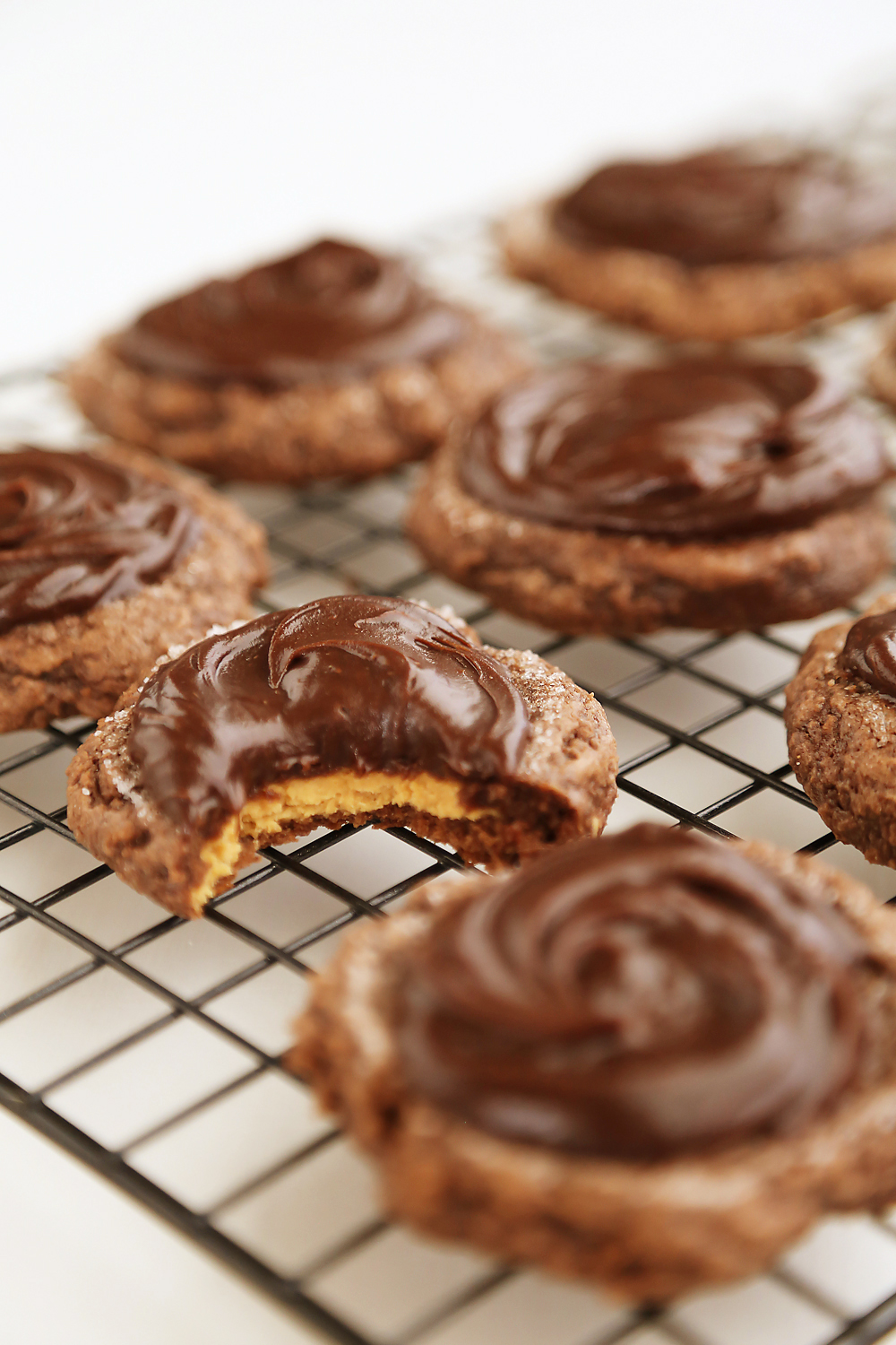 Frosted Peanut Butter Brownie Cookies - Gooey, fudgy chocolate brownie cookies with a surprise peanut butter center! Thecomfortofcooking.com