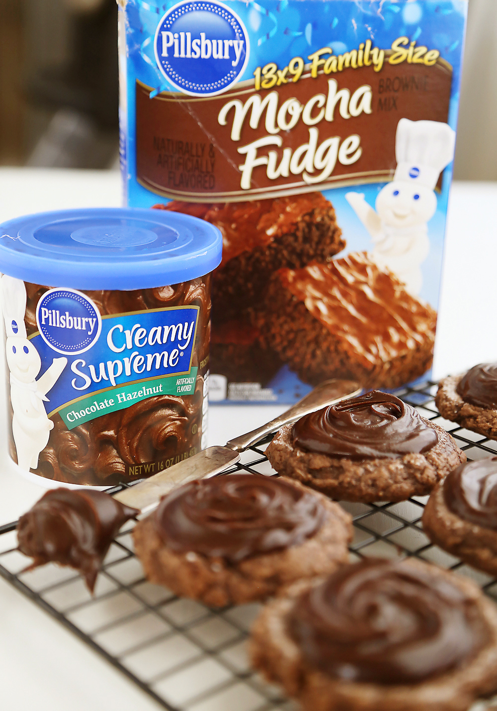 Frosted Peanut Butter Brownie Cookies - Gooey, fudgy chocolate brownie cookies with a surprise peanut butter center! Thecomfortofcooking.com