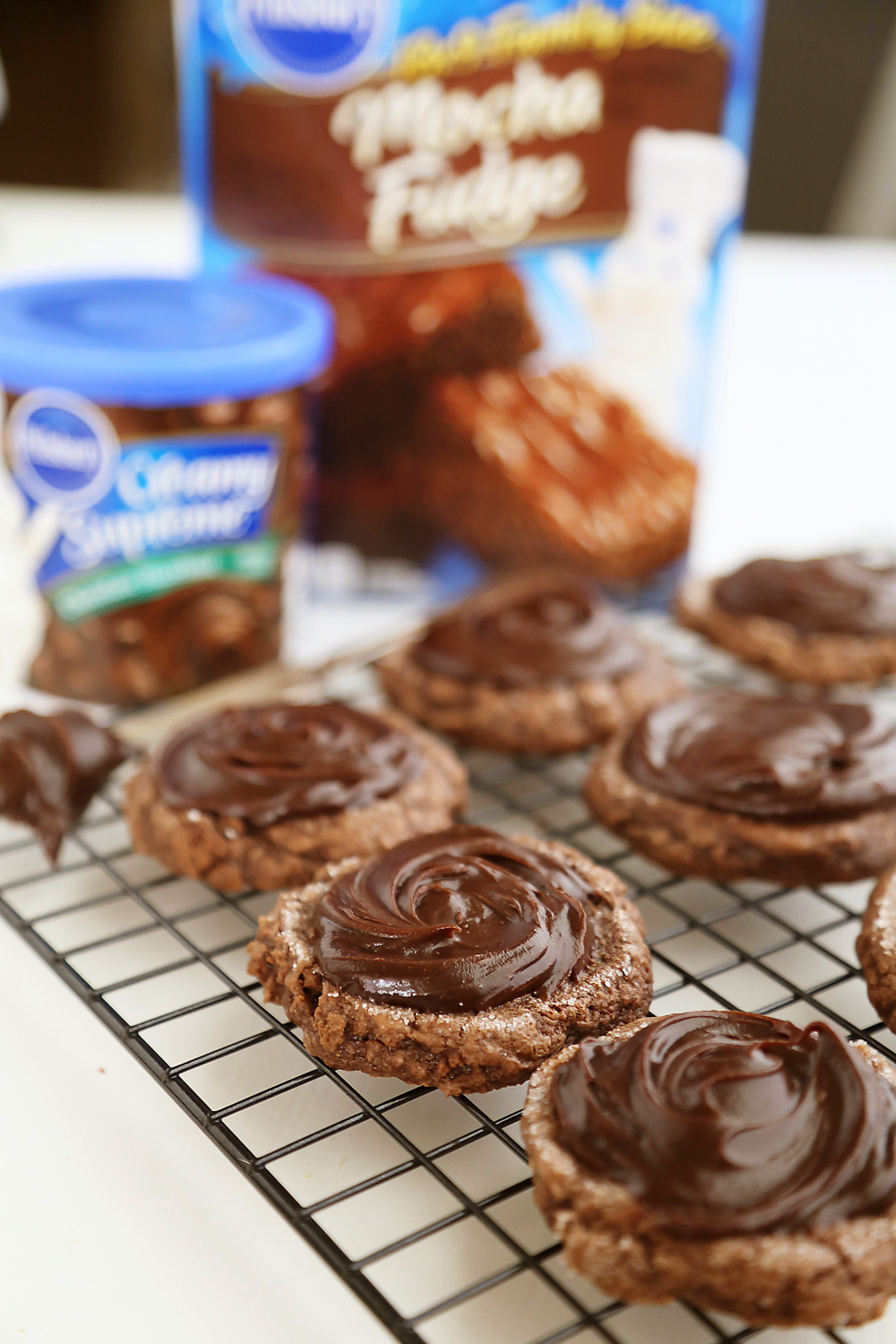 Frosted Peanut Butter Brownie Cookies - Gooey, fudgy chocolate brownie cookies with a surprise peanut butter center! Thecomfortofcooking.com