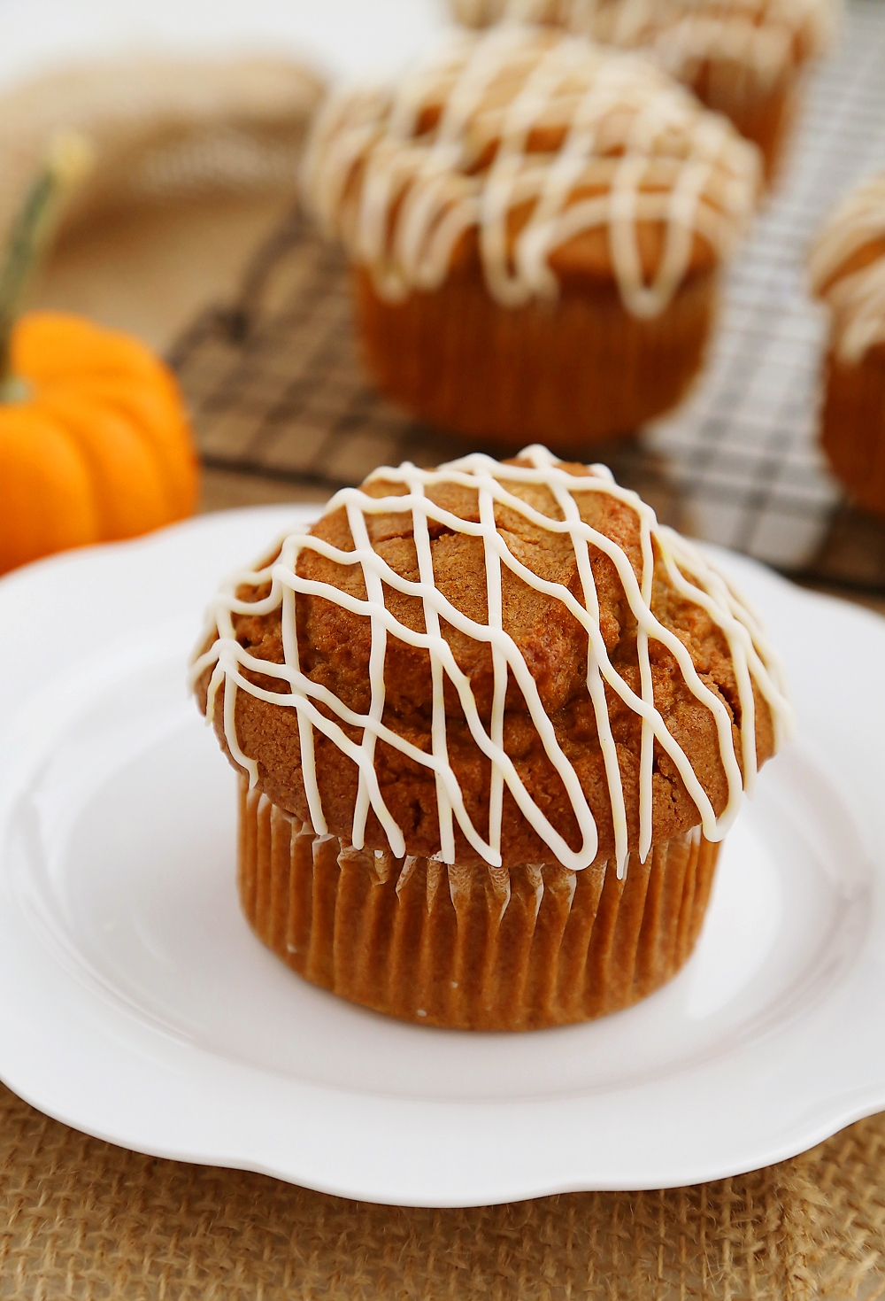 Vanilla Glazed Pumpkin Gingerbread Muffins - Super soft, richly spiced pumpkin muffins made easily in one bowl! So simple, delicious and perfect for homemade gifts. Thecomfortofcooking.com