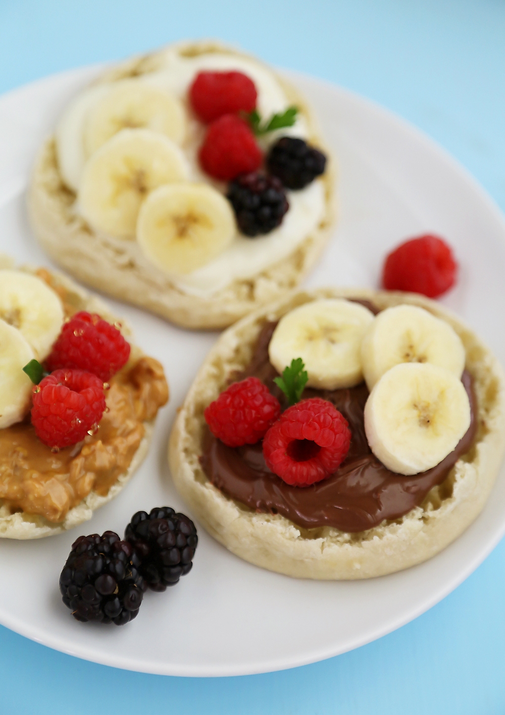 English Muffin Fruit Breakfast Pizzas - Spread with yogurt, Nutella or peanut butter and top with fresh fruit for a delicious morning treat! thecomfortofcooking.com