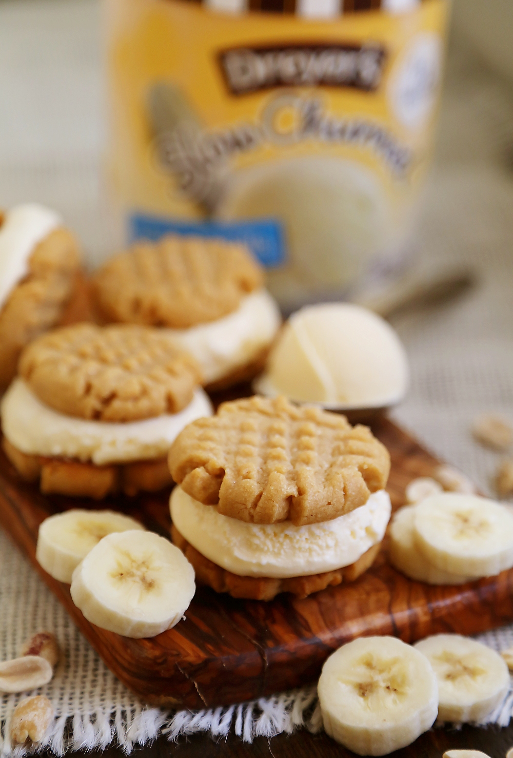 Peanut Butter Cookie + Banana Ice Cream Bites - Homemade cookies with scoops of vanilla ice cream, with fresh bananas mixed right in! Perfect for parties or after-school snacking. Thecomfortofcooking.com