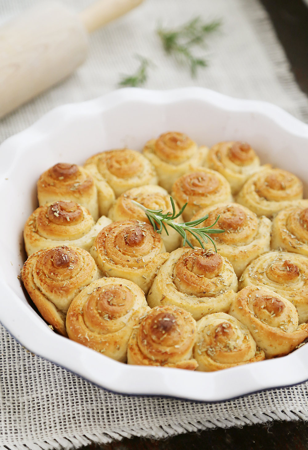Garlic Butter Rosemary Rolls – Fluffy mini rolls made with pizza dough and brushed with a rosemary garlic butter. Perfect for serving with roasts, soups, stews and salads! Thecomfortofcooking.com