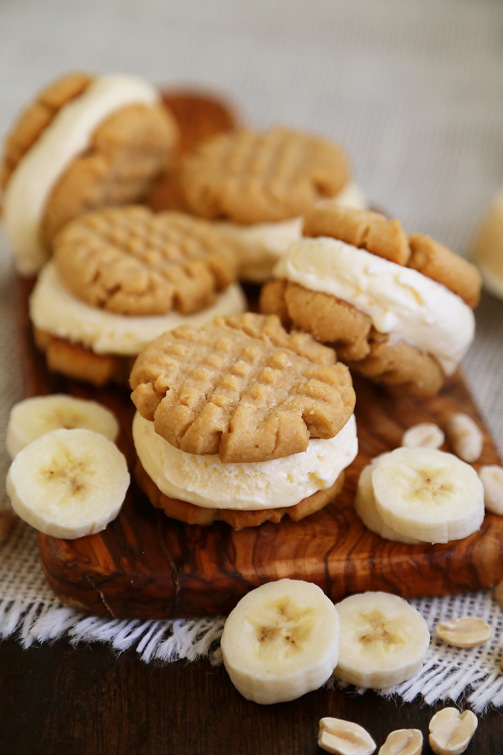 Peanut Butter Cookie + Banana Ice Cream Bites - Homemade cookies with scoops of vanilla ice cream, with fresh bananas mixed right in! Perfect for parties or after-school snacking. Thecomfortofcooking.com