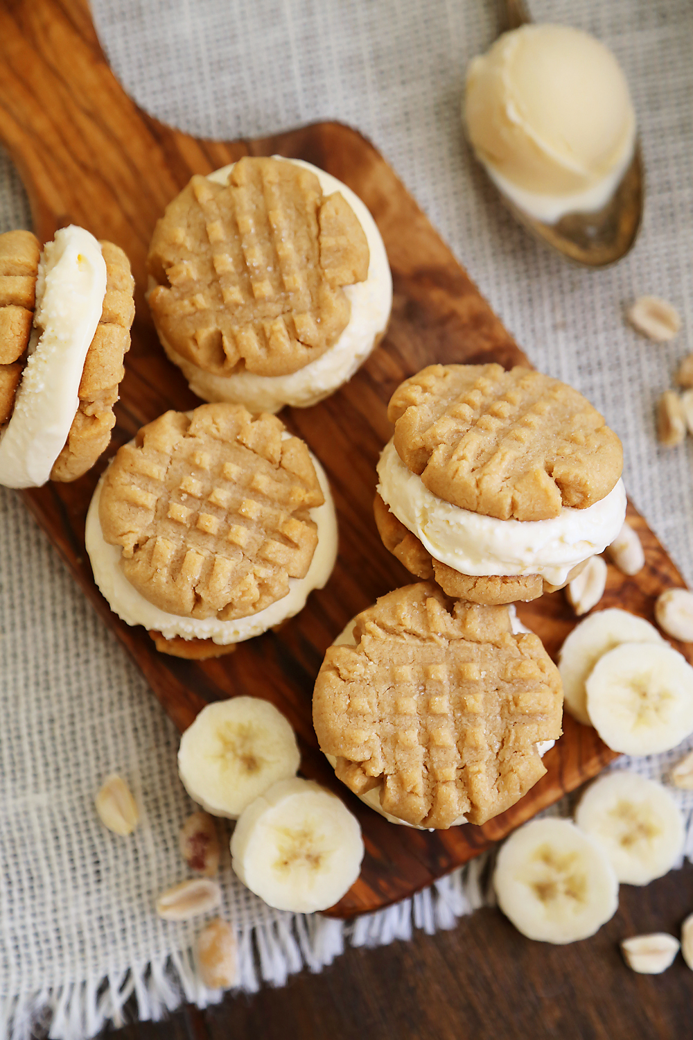 Peanut Butter Cookie + Banana Ice Cream Bites - Homemade cookies with scoops of vanilla ice cream, with fresh bananas mixed right in! Perfect for parties or after-school snacking. Thecomfortofcooking.com