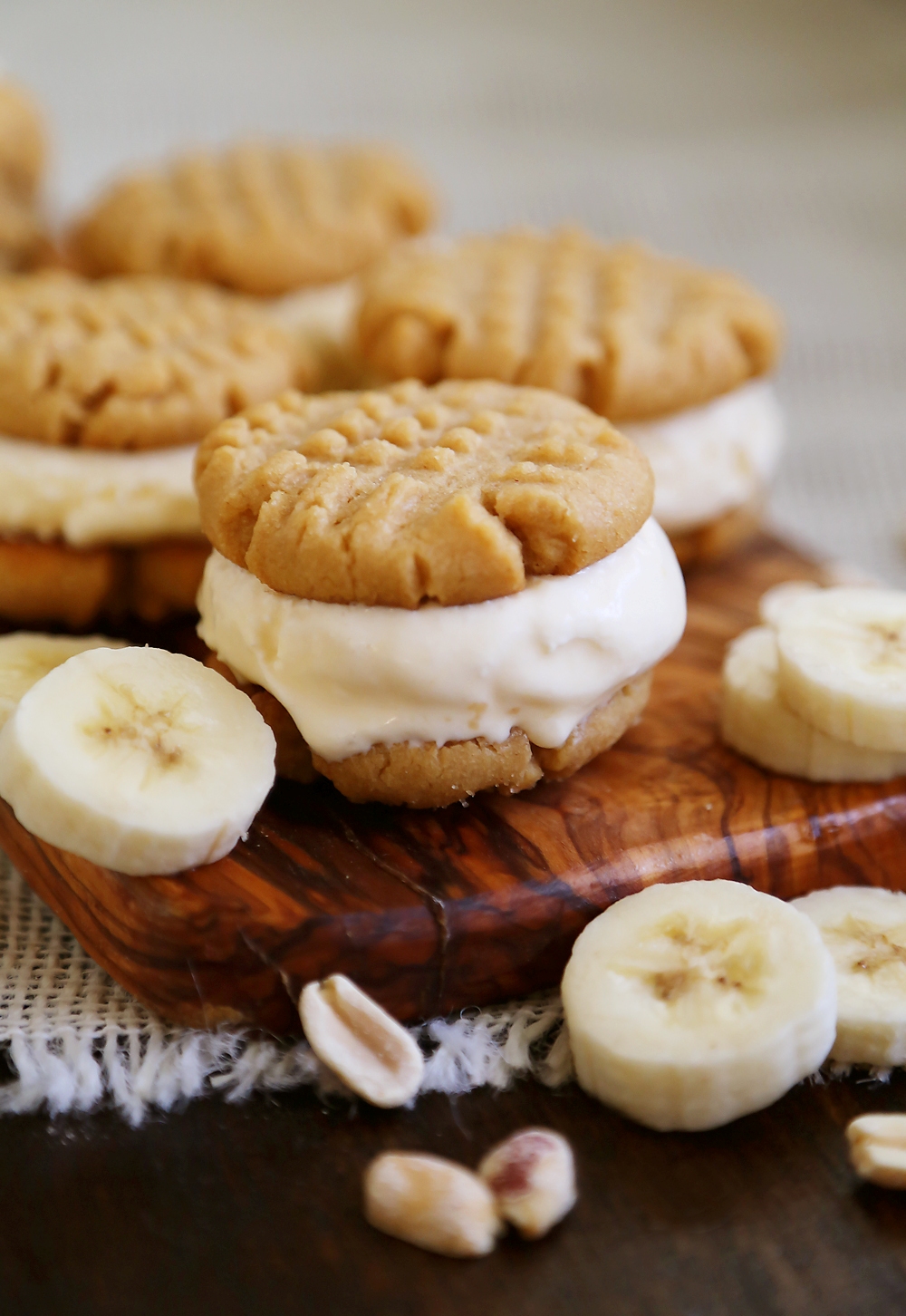 Peanut Butter Cookie + Banana Ice Cream Bites - Homemade cookies with scoops of vanilla ice cream, with fresh bananas mixed right in! Perfect for parties or after-school snacking. Thecomfortofcooking.com