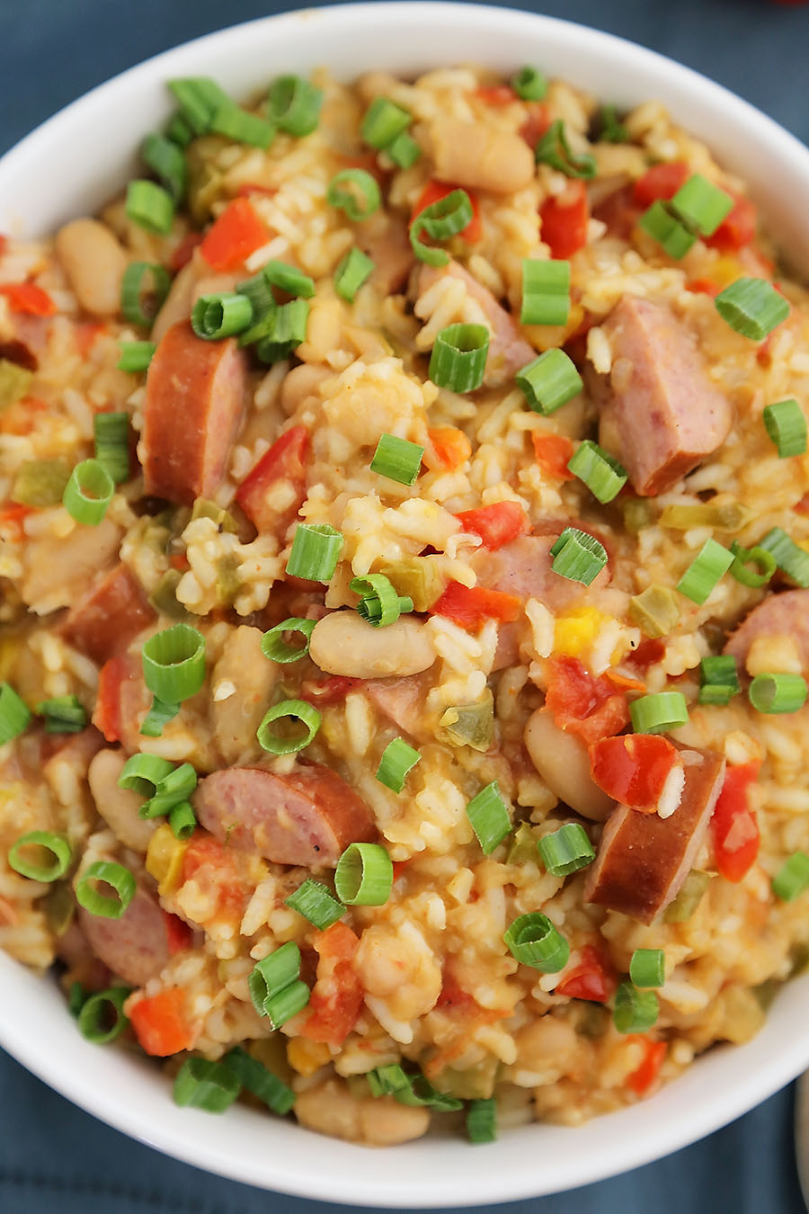 Cajun Sausage, White Bean and Rice Stew - A comforting meal easily cooked on your stovetop! Try this simple spiced Cajun stew with @UncleBensRice, sausage, white beans, tomatoes and bell peppers. thecomfortofcooking.com