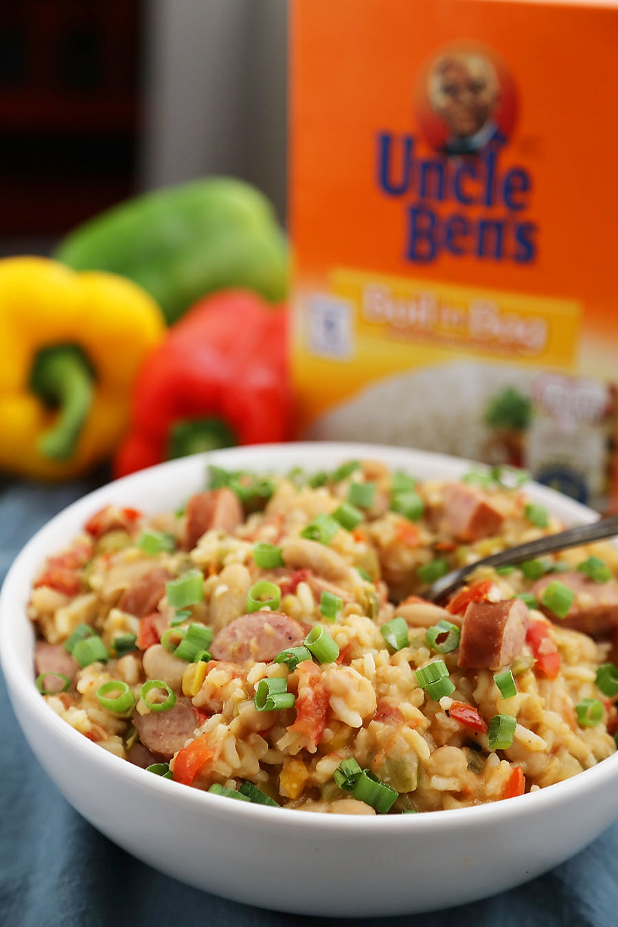 Cajun Sausage, White Bean and Rice Stew - A comforting meal easily cooked on your stovetop! Try this simple spiced Cajun stew with @UncleBensRice, sausage, white beans, tomatoes and bell peppers. thecomfortofcooking.com