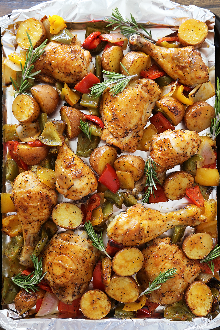 Rosemary Roasted Chicken with Bell Peppers and Potatoes - Crispy, tender roasted chicken with bell peppers, potatoes and onions makes an easy one-pan weeknight meal! Thecomfortofcooking.com