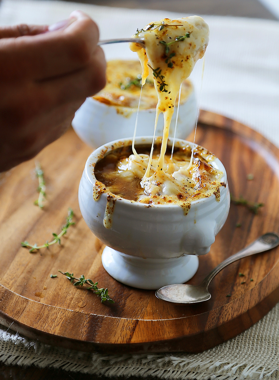 Easy French Onion Soup - Fragrant, cheesy and so comforting! Caramelized onions, beef stock and white (or red) cooking wine mingle into a luxurious medley in this classic French dish. Thecomfortofcooking.com