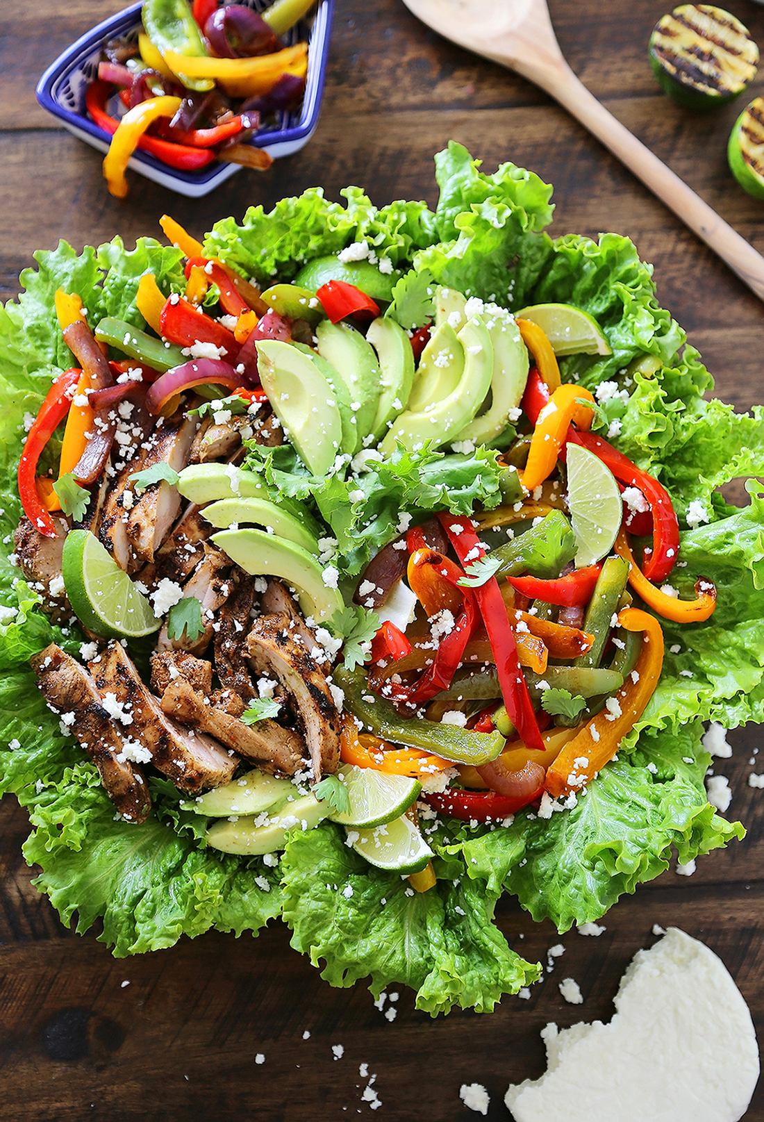 Grilled Chili-Lime Chicken Fajita Salad - Tender, juicy marinated chicken with fresh bell peppers, onions, garlic and avocado slices. SO good. Top with some creamy queso fresco and cilantro for extra eye appeal and flavor! thecomfortofcooking.com