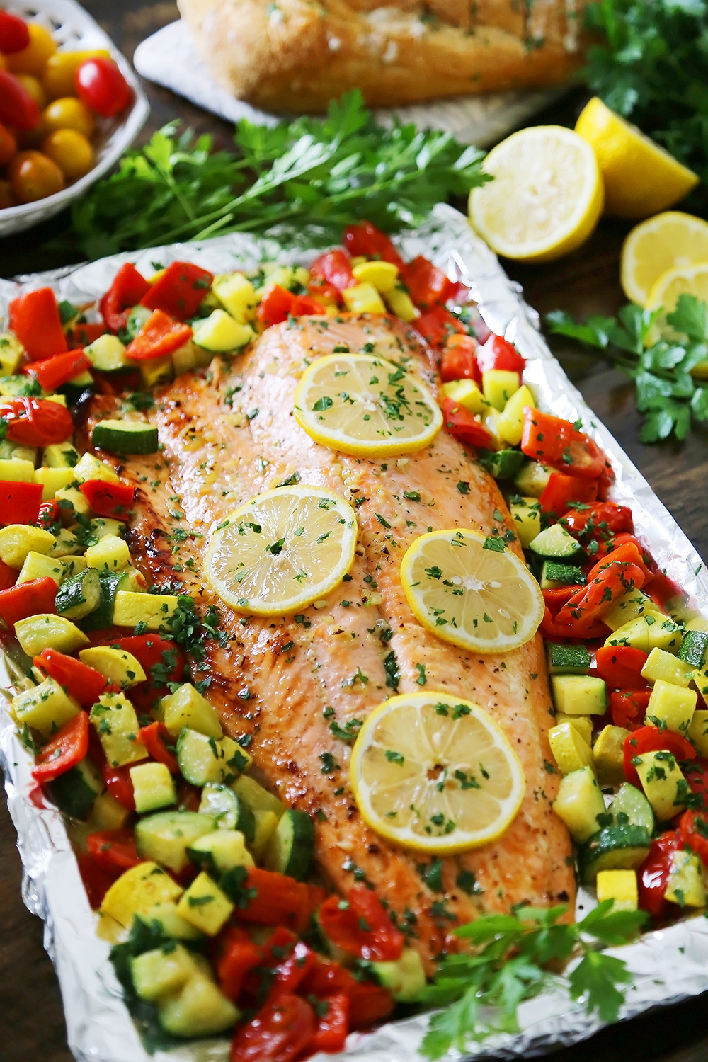Lemon-Garlic Honey Butter Salmon & Veggies in Foil - Juicy, flaky roasted salmon with lemon-garlic honey butter and tender summer veggies! One pan full of hearty, healthy goodness! thecomfortofcooking.com