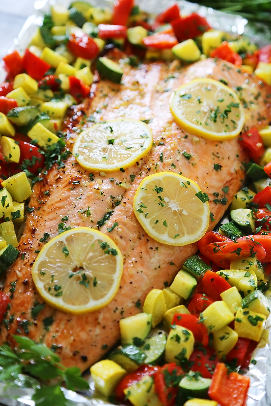 Lemon-Garlic Honey Butter Salmon & Veggies in Foil - Juicy, flaky roasted salmon with lemon-garlic honey butter and tender summer veggies! One pan full of hearty, healthy goodness! thecomfortofcooking.com