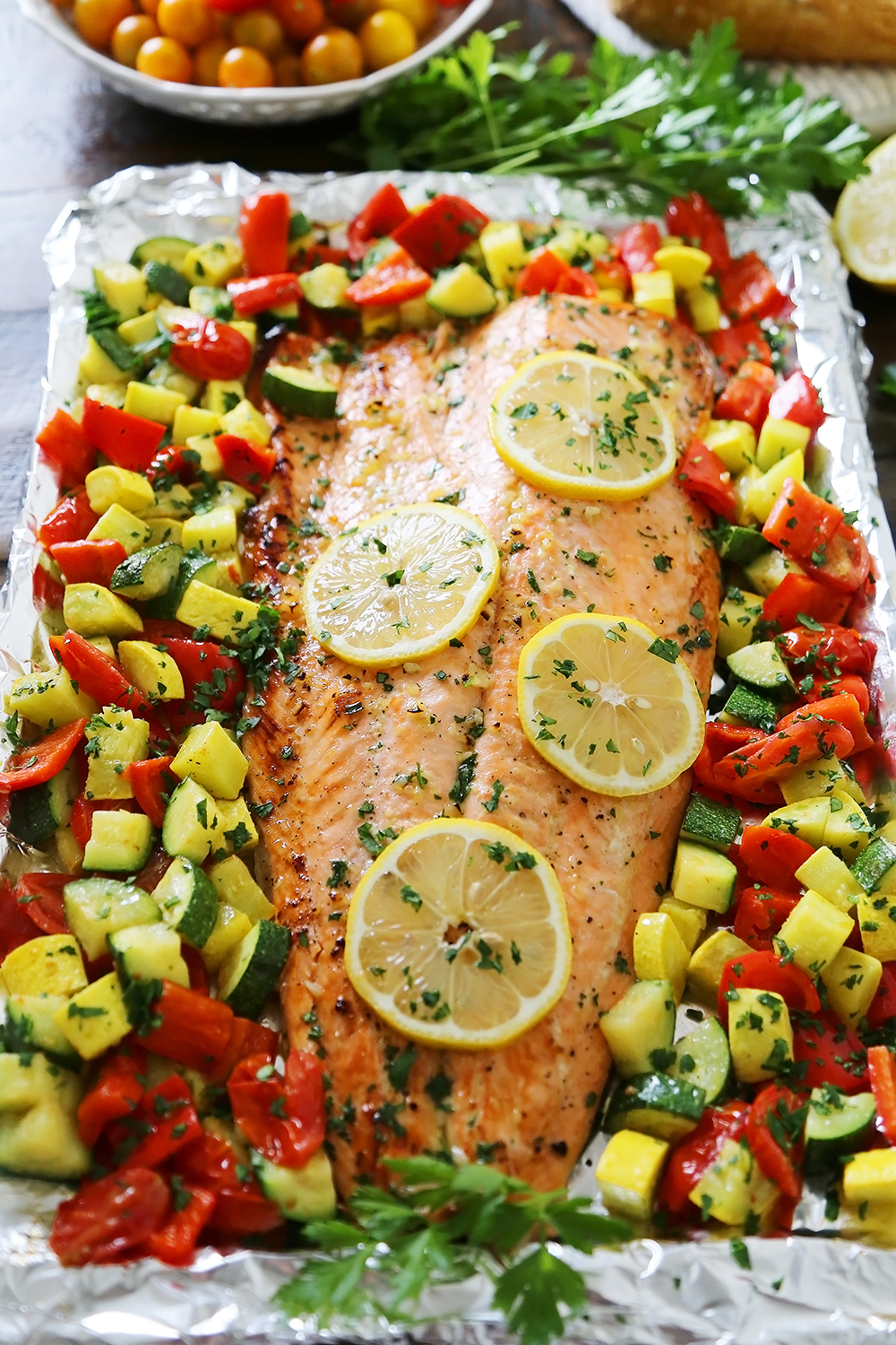 Lemon-Garlic Honey Butter Salmon & Veggies in Foil - Juicy, flaky roasted salmon with lemon-garlic honey butter and tender summer veggies! One pan full of hearty, healthy goodness! thecomfortofcooking.com