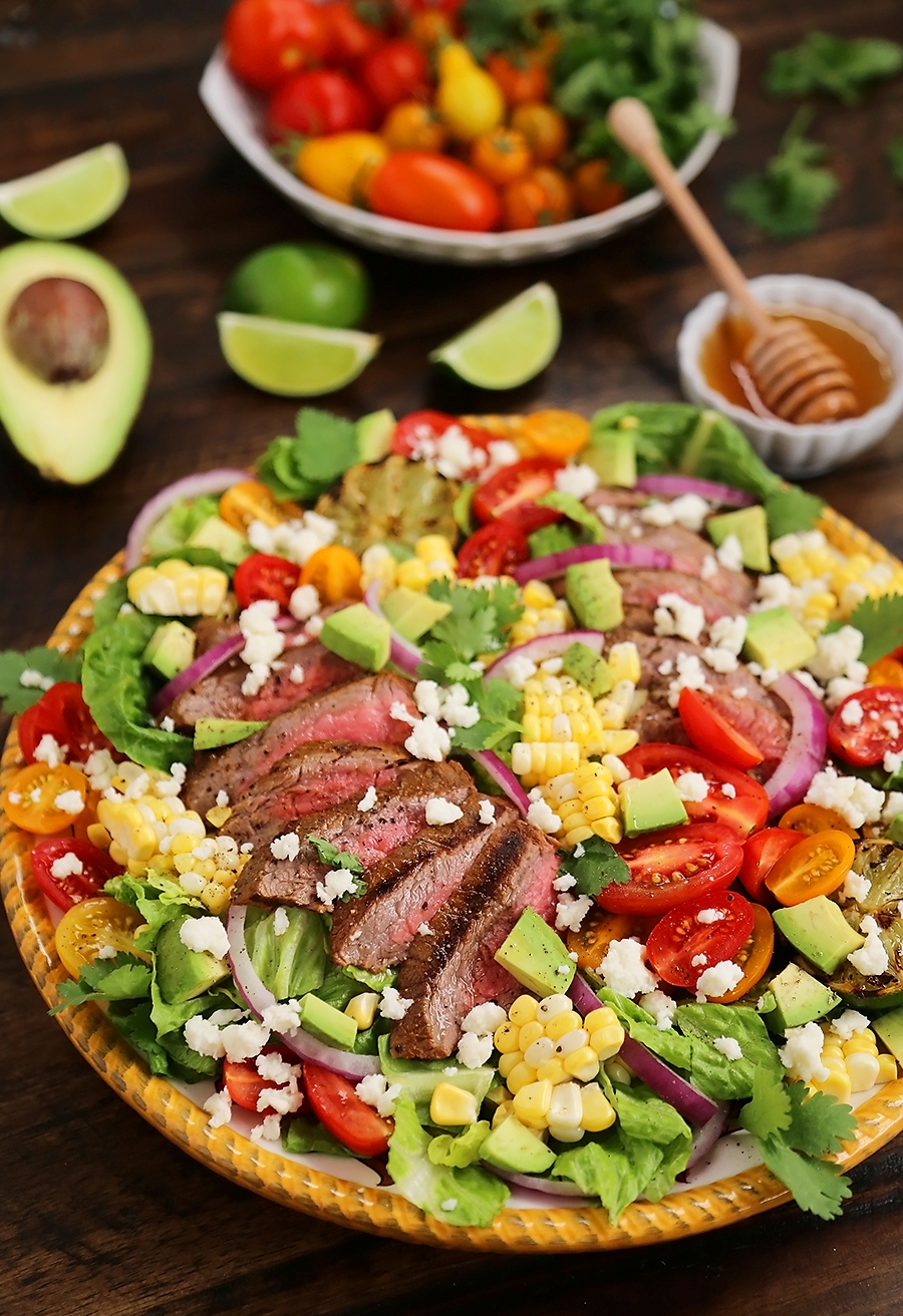 Mexican Grilled Steak Salad with Honey Lime Dressing - Smoky, spicy steak, fresh corn, red onions, creamy avocado and a zesty honey lime dressing. Full of flavor, color and nutritious goodness! Thecomfortofcooking.com