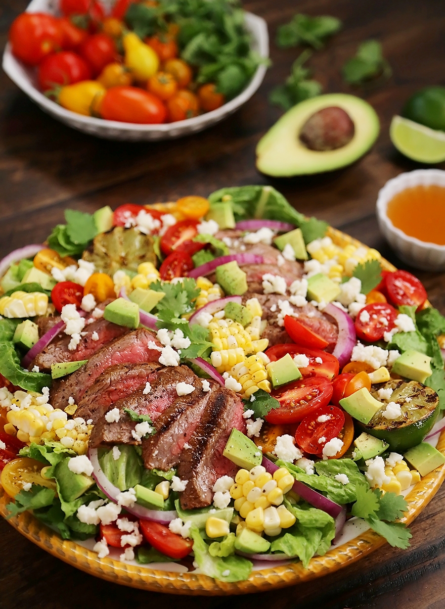 Mexican Grilled Steak Salad with Honey Lime Dressing - Smoky, spicy steak, fresh corn, red onions, creamy avocado and a zesty honey lime dressing. Full of flavor, color and nutritious goodness! Thecomfortofcooking.com