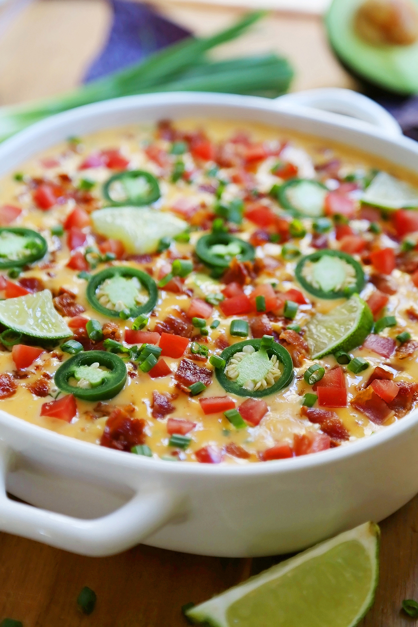 2-Ingredient CrockPot Queso Dip - So easy, cheesy and full of flavor for holiday parties and game day fun. Load it up with bacon, tomatoes, jalapenos and your favorite fixin's! Thecomfortofcooking.com