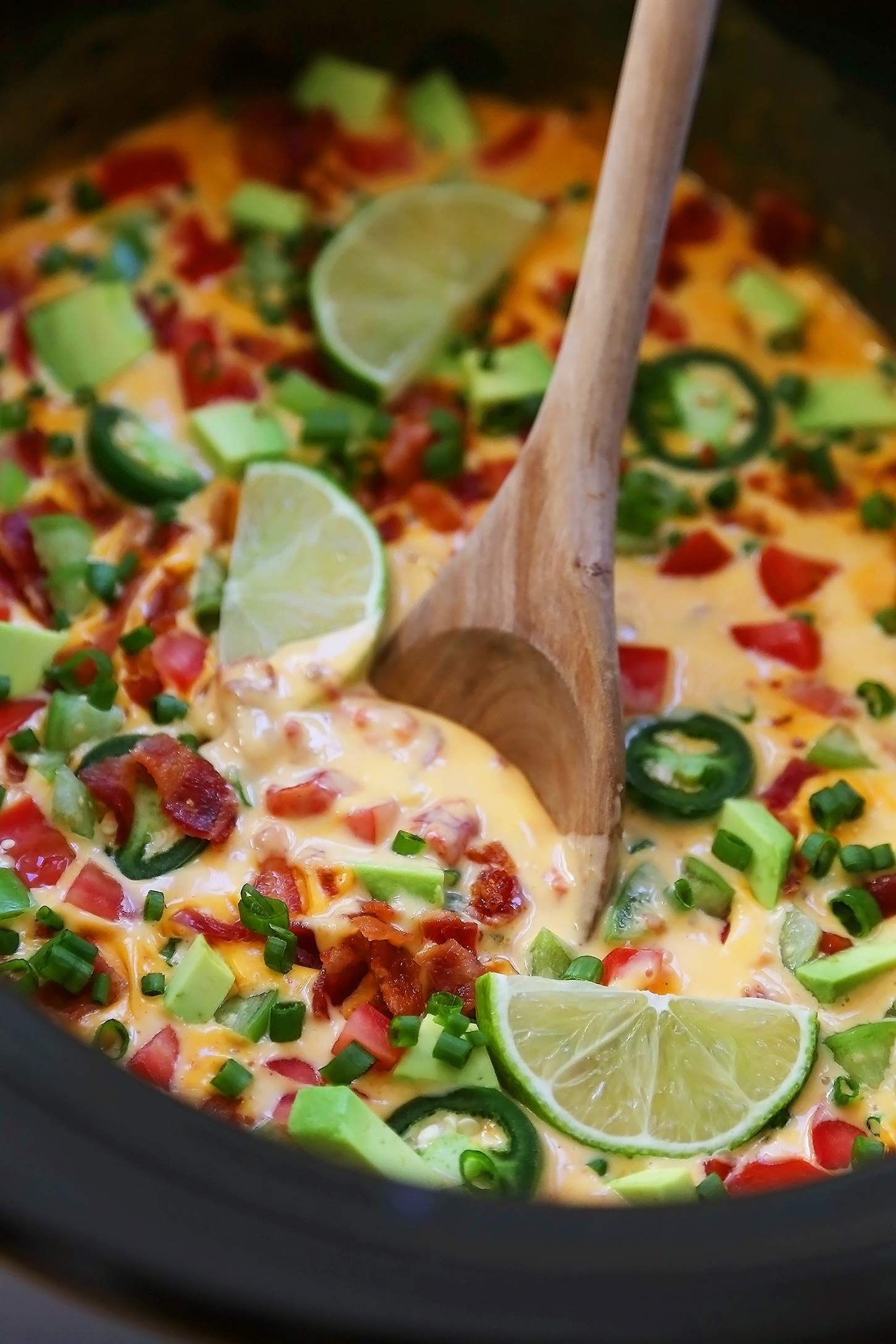 2-Ingredient CrockPot Queso Dip - So easy, cheesy and full of flavor for parties and lazy weekends in. Load it up with bacon, tomatoes, jalapenos and your favorite fixin's! Thecomfortofcooking.com