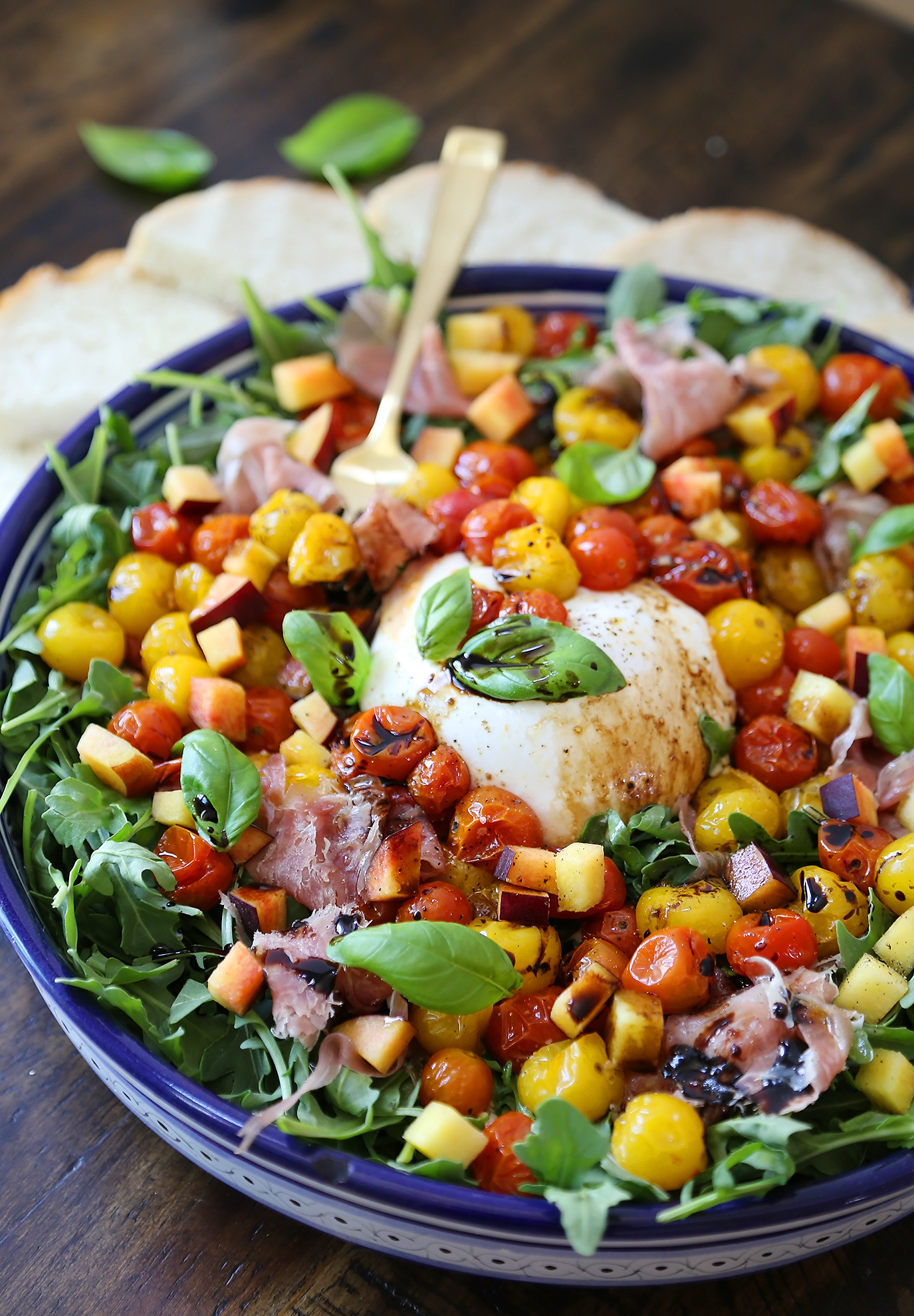 Burrata Caprese Salad with Peach and Proscuitto - Perfect for parties and lazy weeknights! Sweet peaches, salty prosciutto and roasted tomatoes nestled in arugula with fresh mozz. thecomfortofcooking.com